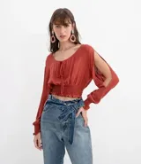 Blusa color ladrillo con escote redondo con ajuste, mangas largas con aberturas en los hombros y elástico en la cintura.
