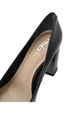 Zapatos de tacón alto negros de cuero con punta fina y tacón geométrico con detalles metálicos.
