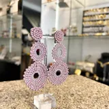 Aros colgantes largos con forma de círculos tramados con cuentas de cristal color turquesa.