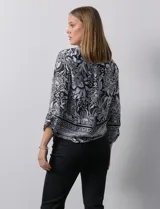 Blusa estampada con escote en V y abertura con botones. Largo de manga regulable con presilla y botón. Terminación de ruedo con nudo.