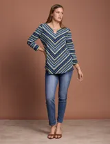 Blusa texturada con cuello redondo y escote en V con aplique metálico. Diseño a rayas horizontales en tonos azul, verde, blanco y negro.