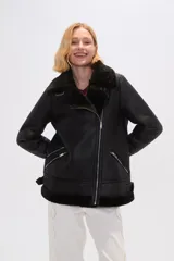 Campera negra de eco cuero con cuello de piel sintética, cierre cruzado con cremallera y bolsillos laterales con cremallera.