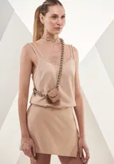 Musculosa color piel con breteles finos con apliques brillantes. Incluye choker plateado y riñonera con cadena de eslabones gruesos.