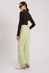 Pantalón de cuero color claro con tiro medio y corte relajado.