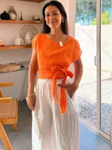 Blusa naranja de lino con mangas cortas y nudo frontal.