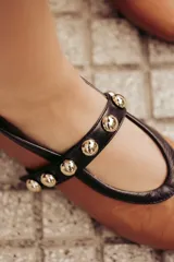 Bailarinas de cuero negro con puntera redondeada y tira sobre el empeine con apliques de esferas metálicas.