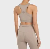 Top deportivo Umbro color beige con pretina diferenciada con la leyenda "PRO TRAINING" y transparencias de mesh en el pecho.