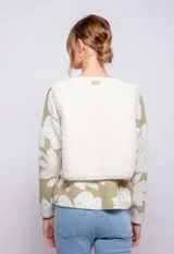 Chaleco corto de textil tipo corderito color beige, con botones metalizados y cuello a la base.