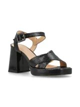 Sandalias de cuero color canela con plataforma y tacón ancho. Tiras cruzadas en el empeine y pulsera ajustable con hebilla en el tobillo.