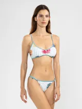 Top de bikini blanco con rayas verticales celestes y estampado de flores de colores.