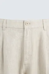 Pantalón de vestir blanco, confeccionado en lino, de corte recto, con bolsillos laterales y traseros. Se ajusta a la cintura con botón y cierre.