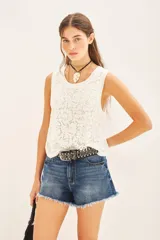 Musculosa blanca de encaje con cuello redondo.