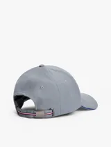 Gorra de béisbol gris de seis paneles confeccionada en franela de puro algodón, con botón en la parte superior, ojales de ventilación, hebilla de ajuste metálica en la parte trasera, detalle distintivo en la hebilla de ajuste, logo esmaltado en la parte delantera y logo en bajo relieve en la hebilla de ajuste.