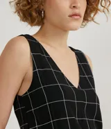Mono corto negro con estampado de cuadrillé blanco, escote en V y tirantes anchos.