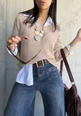 Sweater beige de hilo con cuello redondo y mangas largas.