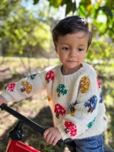 Sweater tejido de lana merino color crema con cuello redondo y diseño de hongos bordados a mano en colores azul, rojo, mostaza y verde.