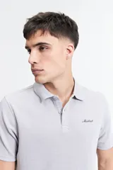 Remera polo gris claro con textura, corte regular y logo bordado en el pecho.