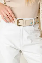 Cinturón color beige de cuero vacuno con hebilla metálica color bronce y apliques de tachas y turquesas.