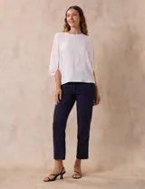 Blusa de gasa color blanco con estampado de hojas verdes, de mangas 3/4 abullonadas con puños elásticos.