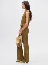 Pantalón de jean azul de tiro alto y corte oxford con apliques metálicos en bolsillos y laterales.