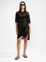 Camisa larga negra de punto calado con cuello camisero, manga tres cuartos y cierre frontal con botones.