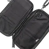 Bandolera porta documentos negra de tela con correa ajustable. Tiene cierre principal, bolsillo interno con cierre, bolsillo externo con cierre y varios compartimentos para tarjetas y billetes.