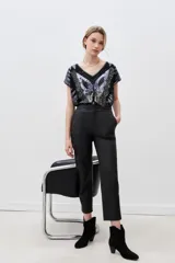 Pantalón de cuero ovino negro, de corte recto y largo al tobillo. Presenta un acabado metalizado plateado.