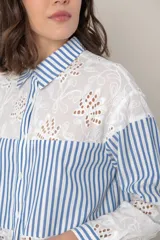 Camisa blanca de algodón con bordado calado y rayas celestes.