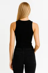 Musculosa de bretel ancho color negro, de algodón, lisa, al cuerpo y con cuello redondo.