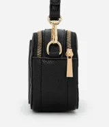 Cartera bandolera negra de poliuretano con textura en relieve. Tiene correa larga desmontable, cierre de cremallera y dos bolsillos internos.