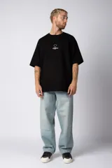 Remera color crudo de corte oversize con estampado pequeño en el centro del pecho.