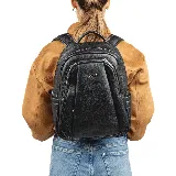 Mochila negra de cuero sintético con cierre superior y múltiples bolsillos externos.