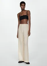 Pantalón de vestir color crudo, de corte recto y tiro medio, con cierre lateral de cremallera.