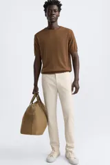 Pantalón chino azul marino, corte skinny fit, confeccionado en tejido de algodón con elasticidad. Cuenta con bolsillos frontales y traseros de vivo. Cierre frontal con cremallera y botón.