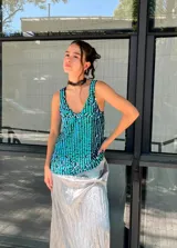 Musculosa con escote en V y breteles anchos, confeccionada en tela de lentejuelas color turquesa y verde.