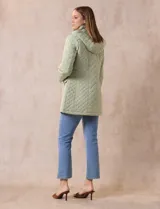 Campera capitoneada verde claro, marca Gallery, con abertura central con cierre, bolsillos delanteros y capucha desmontable. Forro interno a tono.
