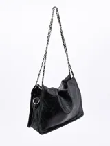 Cartera negra con textura arrugada y correa de cadena plateada.