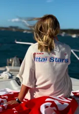 Camiseta celeste con estampado frontal y trasero con el texto "Ittai Stars" en color rojo y azul.