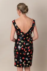 Vestido de lentejuelas negro con bordados de flores en colores vibrantes, de línea recta y cuello en barco.