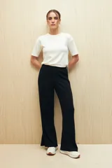 Pantalón negro de punto, corte suelto, con elástico en la cintura y aberturas en el ruedo.