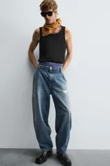 Pantalón de jean azul de corte amplio, con roturas y lavado gastado.