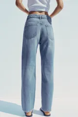 Pantalón de jean celeste de tiro alto, corte mom fit, largo regular y roturas en las rodillas.