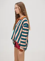 Chomba de corte oversize con cuello camisero, a rayas verticales en color marrón, lila y blanco. Tiene un logo bordado en el pecho y puños en color marrón.