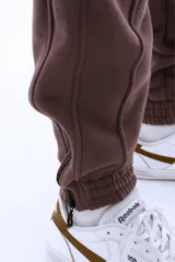 Pantalón de jogging marrón de algodón grueso con interior abrigado, corte amplio, tiro medio, cintura elástica con cordón, bordado mini “vernal” en pierna izquierda, cierres en botamanga para regular el ajuste y detalle de logo V en bordado mini sobre la pantorrilla.