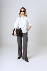 Camisa blanca de corte holgado, cuello mao y mangas largas con puños fruncidos.