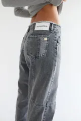 Pantalón de jean azul de corte recto y tiro medio, con lavado desgastado, pespuntes en rojo y deshilachado en la pretina.