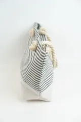 Bolso tipo tote con rayas horizontales rojas y blancas en la parte superior y base color beige. Asas de soga gruesa.