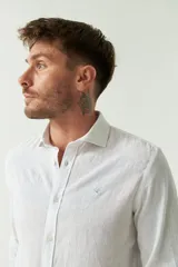 Camisa de manga larga color amarillo claro, confeccionada en lino y algodón, corte semi slim y logo bordado.