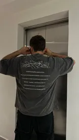 Remera gris con efecto acid wash y estampado en la espalda con logo de videojuego.