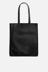 Bolso tipo shopper fabricado en cuero color negro. Tiene un bolsillo interior plano con cierre mediante cremallera y asas de cuero.
